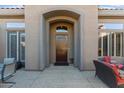 Dark wood front door with sidelights and a courtyard view at 2223 W Hazelhurst Ct, Anthem, AZ 85086