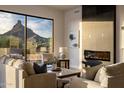 Sunlit living room featuring a cozy fireplace and stunning mountain views at 25838 N 104Th Pl, Scottsdale, AZ 85255