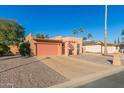 Tan stucco house with a pink garage door and a gravel driveway at 26430 S Pinewood Dr, Sun Lakes, AZ 85248