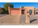 Tan stucco house with a pink garage door and a gravel driveway at 26430 S Pinewood Dr, Sun Lakes, AZ 85248