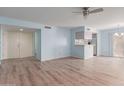 Light blue living room with wood-look floors and access to the kitchen at 26430 S Pinewood Dr, Sun Lakes, AZ 85248