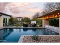 Inviting backyard oasis featuring a sparkling pool, fire pit, and pergola at 29615 N 55Th Pl, Cave Creek, AZ 85331