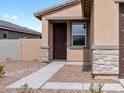 Close up of front door with window, desert landscaping, and stone veneer siding at 3208 E Hayden Rose Ave, San Tan Valley, AZ 85143