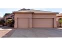 Tan house with two-car garage and nicely manicured landscaping at 3403 E Wyatt Way, Gilbert, AZ 85297