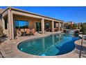 Inviting kidney-shaped pool with a waterfall feature and patio furniture at 3649 N Hudson Dr, Florence, AZ 85132