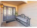 Front entry with a dark gray door, sidelights and a bench at 4129 W Hearn Rd, Phoenix, AZ 85053