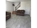 Living room with brown couch and grey tile floor at 4714 E Broadway Rd, Phoenix, AZ 85040