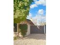 Backyard with gravel ground, flowering bushes, and a wooden gate at 6258 E Ivy St, Mesa, AZ 85205