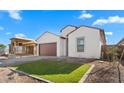 New construction home with brown garage door and grassy front yard at 699 E Greenback Dr, San Tan Valley, AZ 85140