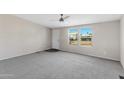 Spacious living room with grey carpet and ceiling fan at 8155 E Baltimore St, Mesa, AZ 85207