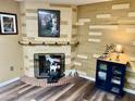 Cozy living room featuring a fireplace and wood-look floors at 9746 N 105Th Dr, Sun City, AZ 85351