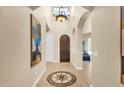 Elegant entryway with high ceilings, tile flooring, and a statement chandelier at 11729 N 134Th St, Scottsdale, AZ 85259