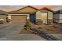 Charming single-story home with a well-manicured front yard and an attached two-car garage at 16790 W Molly Ln, Surprise, AZ 85387