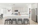 Spacious kitchen featuring a large island with seating, stainless steel appliances, and white cabinets at 16790 W Molly Ln, Surprise, AZ 85387