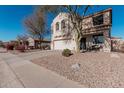 Two-story house with a tree in front and a gravel driveway at 17774 W Watson Ln, Surprise, AZ 85388