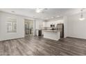 Open-concept living area with sliding glass door to balcony and view into the modern kitchen at 22125 N 29Th Ave # 127, Phoenix, AZ 85027