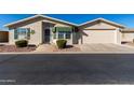 Tan single-story home with a two-car garage and landscaping at 3301 S Goldfield Rd # 4086, Apache Junction, AZ 85119