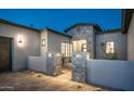 Home entrance featuring stone pillars, accent lighting, and desert landscaping at 4215 S Willow Springs Trl, Gold Canyon, AZ 85118