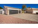 House exterior showcasing a three-car garage and stone detailing at 4430 E Graythorn St, Phoenix, AZ 85044