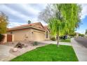 Tan house with tile roof, attached garage, and mature landscaping at 6458 E Raftriver St, Mesa, AZ 85215