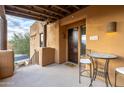 Building entry with a dark wood door and small patio seating at 13450 E Via Linda Dr # 2008, Scottsdale, AZ 85259