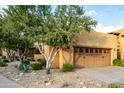 Two-car garage with wood-like garage doors and desert landscaping at 13450 E Via Linda Dr # 2008, Scottsdale, AZ 85259