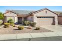 Single-story home with solar panels and a two-car garage at 15174 W Camino Estrella Dr, Surprise, AZ 85374