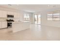 Open-concept kitchen with white cabinets, stainless steel appliances, and island at 24914 N 173Rd Ln, Surprise, AZ 85387