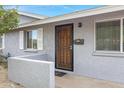 Close up of the front door with a small retaining wall and window with shutters at 3247 E Friess Dr, Phoenix, AZ 85032