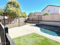 Home with fenced backyard, grassy area, and inviting kidney-shaped pool at 43439 W Magnolia Rd, Maricopa, AZ 85138