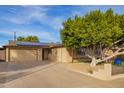 Single story home with solar panels, driveway and mature landscaping at 8644 E Roanoke Ave, Scottsdale, AZ 85257