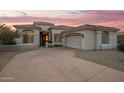 Desert home with a three-car garage, nicely landscaped, and a gorgeous sunset at 11003 E Turnberry Rd, Scottsdale, AZ 85255