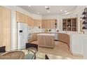 Spacious kitchen with light wood cabinets, an island, and stainless steel appliances at 11003 E Turnberry Rd, Scottsdale, AZ 85255
