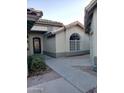 Side view of house with walkway, landscaping, and arched window at 14371 W Morning Star Trl, Surprise, AZ 85374