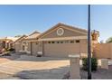 Tan two-story house with a three-car garage and desert landscaping at 15491 W Amelia Dr, Goodyear, AZ 85395