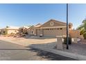 Tan two-story house with a three-car garage and desert landscaping at 15491 W Amelia Dr, Goodyear, AZ 85395