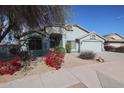 House exterior with a two-car garage and red flowers at 16796 W Pierce St, Goodyear, AZ 85338