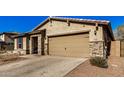 Modern home exterior with a two-car garage and brick pavers at 18188 W Fulton St, Goodyear, AZ 85338