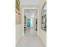 Bright hallway with a view of a teal entry door and modern decor at 18188 W Fulton St, Goodyear, AZ 85338