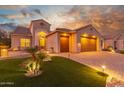 Beautiful two-story home with a three-car garage and manicured lawn at 2562 N 169Th Ave, Goodyear, AZ 85395