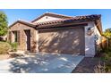 Single-story home with brown brick exterior, two-car garage, and landscaped front yard at 25823 N 122Nd Ln, Peoria, AZ 85383