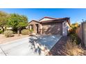 Single-story home with brown brick exterior, two-car garage, and landscaped front yard at 25823 N 122Nd Ln, Peoria, AZ 85383