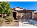 Single-story home with brown brick exterior, two-car garage, and landscaped front yard at 25823 N 122Nd Ln, Peoria, AZ 85383