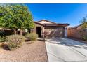 Single-story home with brown brick exterior, two-car garage, and landscaped front yard at 25823 N 122Nd Ln, Peoria, AZ 85383
