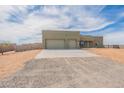Single-story home with two-car garage on a sunny day showing driveway, desert landscape, and block fence at 29340 N 231St Ave, Wittmann, AZ 85361