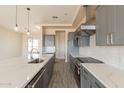 Modern kitchen features a large island with a sink, stainless steel appliances, and quartz countertops at 29380 N 231St Ave, Wittmann, AZ 85361