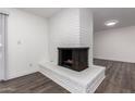 White brick fireplace in living room with dark hardwood floors at 3250 W Mercer N Ln, Phoenix, AZ 85029