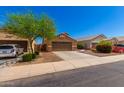 Single-story house with brown exterior, two-car garage, and landscaped front yard at 36532 W Barcelona Ln, Maricopa, AZ 85138