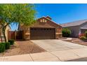 Single-story house with brown exterior, two-car garage, and landscaped front yard at 36532 W Barcelona Ln, Maricopa, AZ 85138