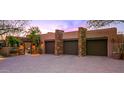 Three-car garage with stone facade and gated entry at 40980 N 97Th St, Scottsdale, AZ 85262